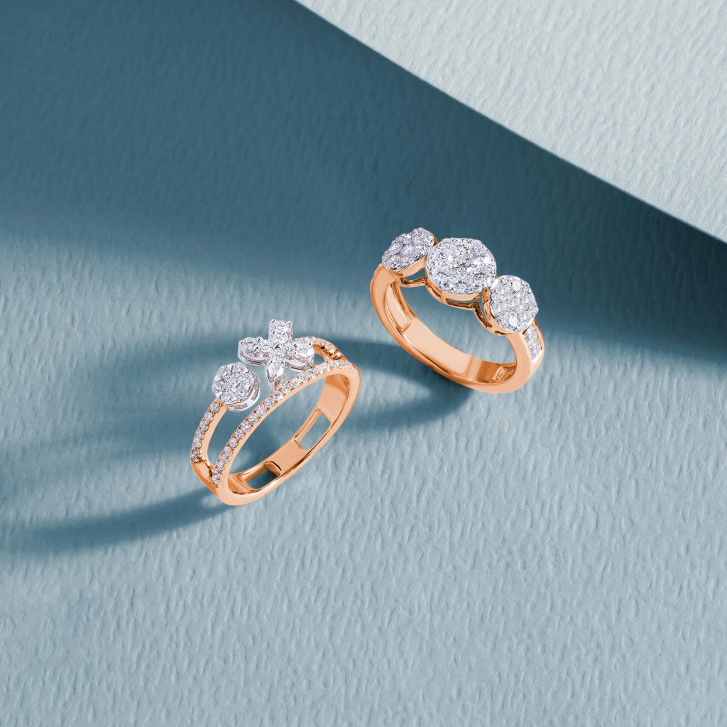 Close-up of luxurious diamond rings on a textured blue surface, showcasing elegance and craftsmanship.