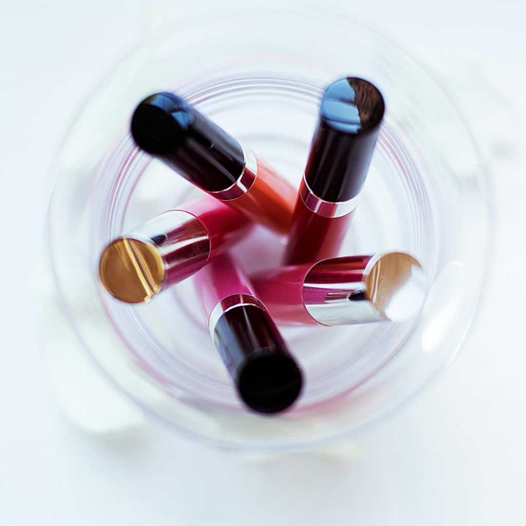 A creative top-down image of various lipsticks in a glass, highlighting color and arrangement.