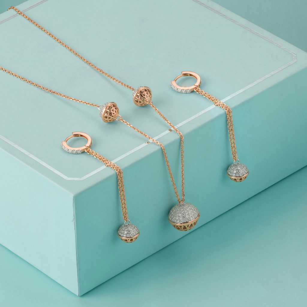 Luxurious jewelry set featuring earrings and necklace displayed on teal box. Ideal for fashion and accessory themes.